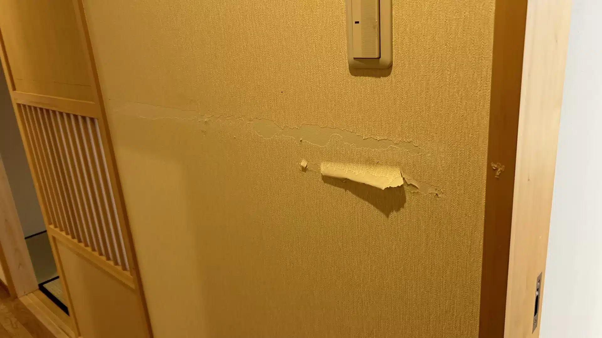 壁のクロスが剥がれている様子（修正前）