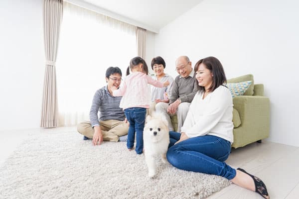 リビングでくつろぐ三世代家族と犬