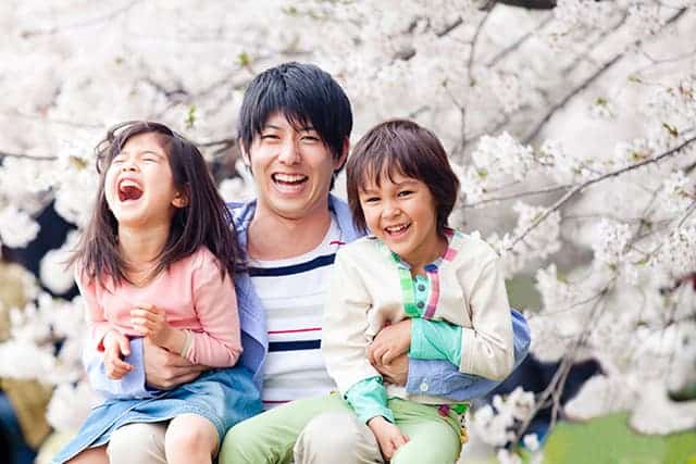 桜の木を背景にした家族写真